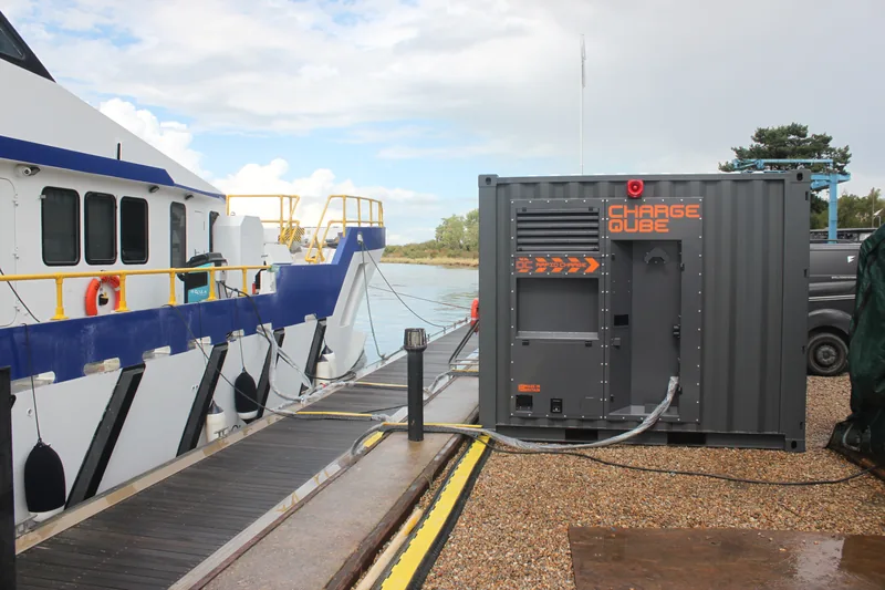 A Charge Qube CQ450 container beside a pontoon, cable running to a crew transfer vessel