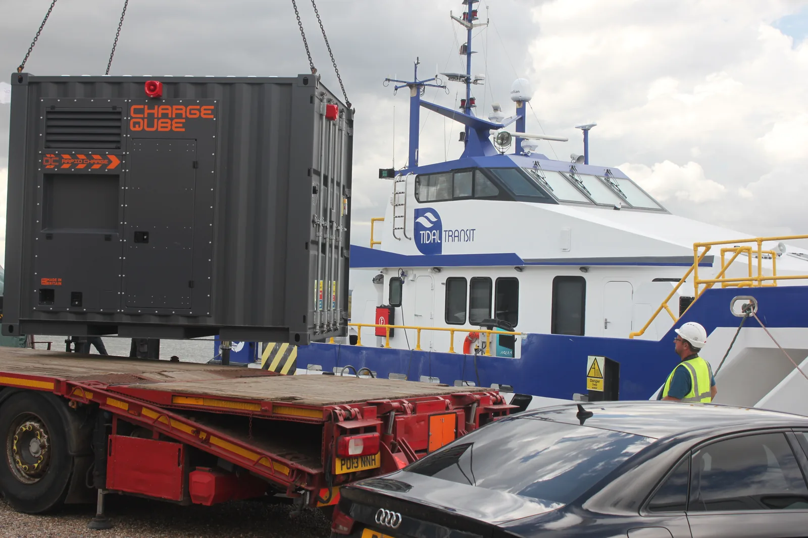 The CQ450 container being craned off a flatbed lorry at the quayside, with a Tidal Transit vessel moored behind